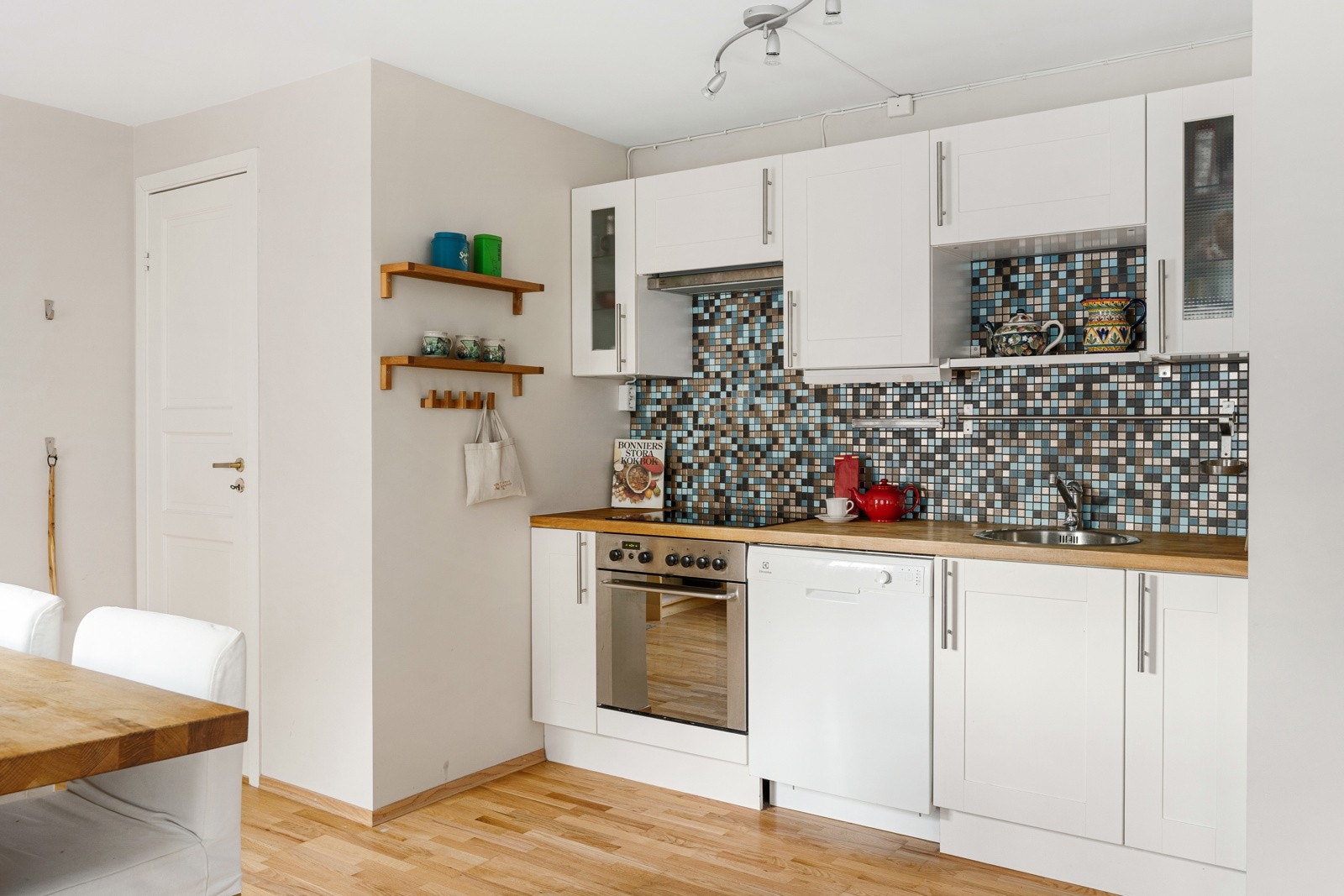 Kjøkkeninnredningen har integrert stekeovn, koketopp, vaskemaskin og plass for kjøleskap. Galleribilde