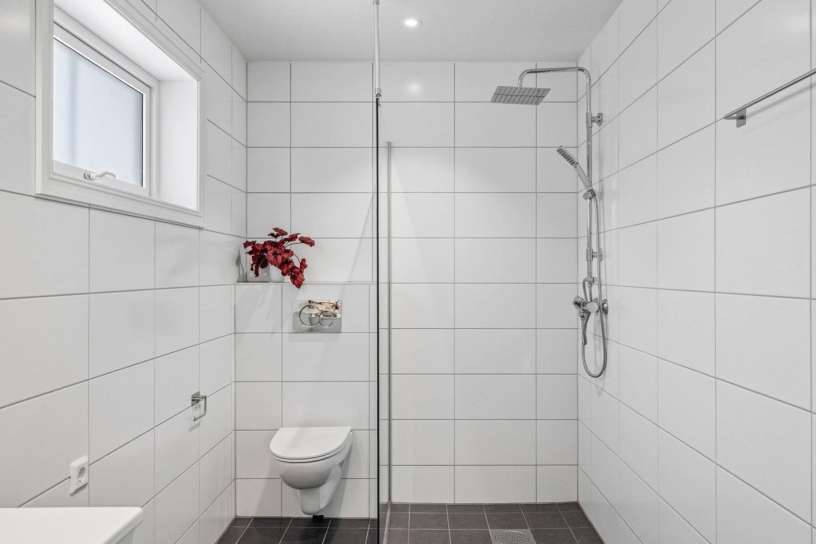 Badet er utstyrt med vegghengt toalett og opplegg for vaskemaskin og tørketrommel. Galleribilde