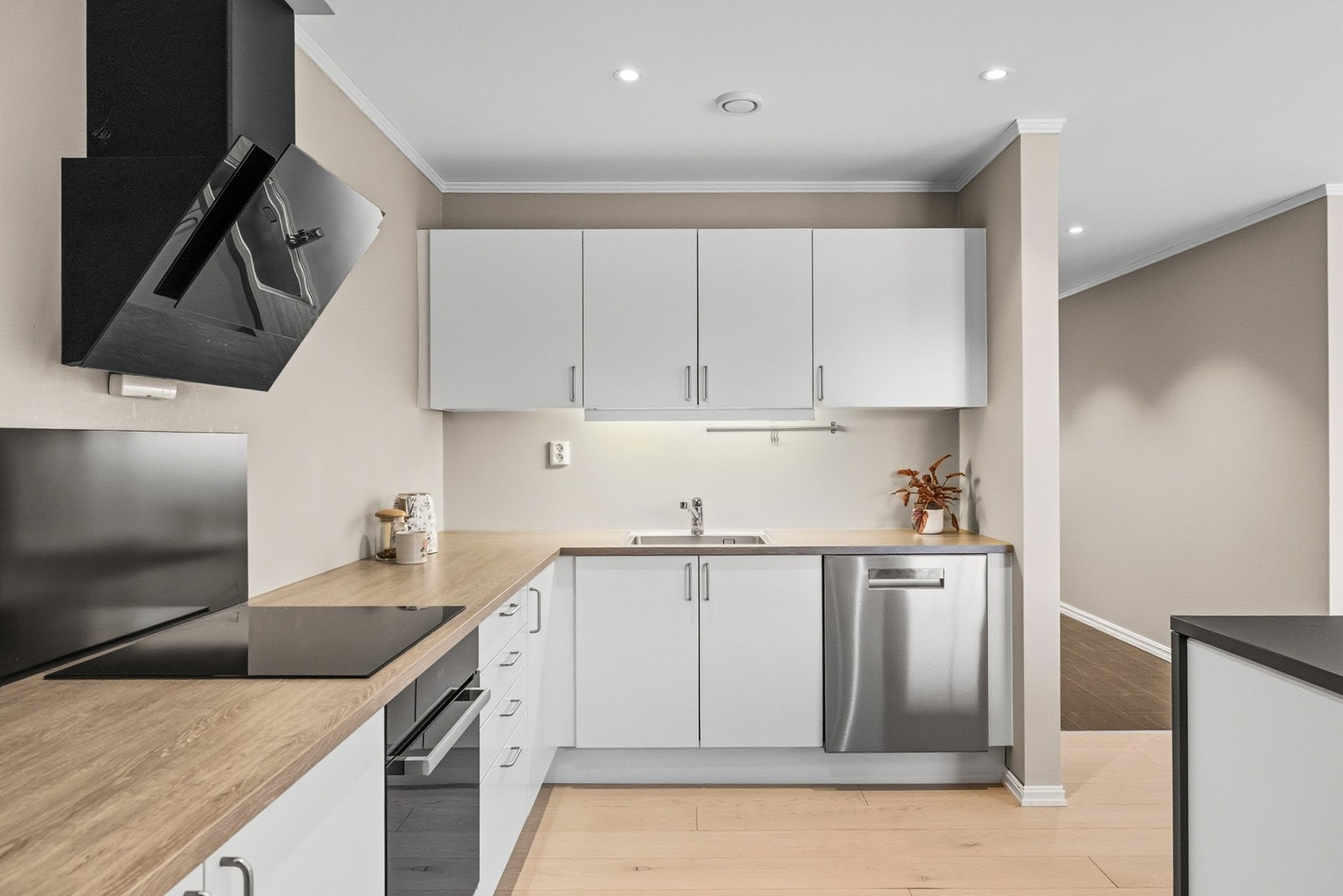 Her får du innredning med hvite slette fronter og rikelig med benkeplate i slitesterk laminat. Galleribilde