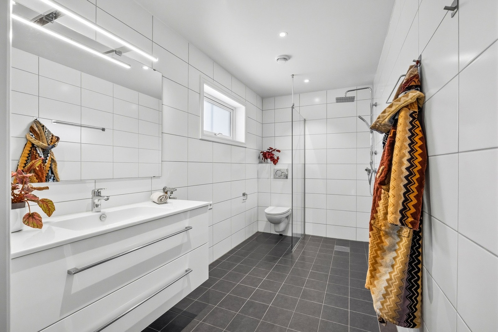 Baderommet har fliser på gulv og vegger og elektriske varmekabler. Galleribilde