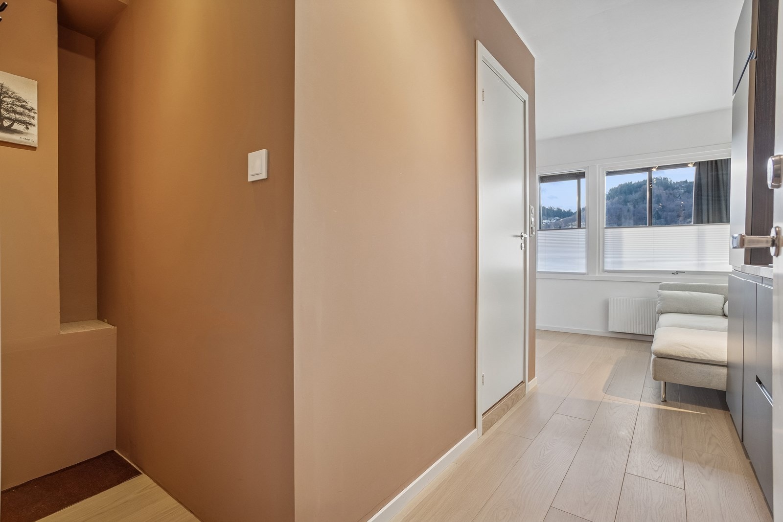 Fra entréen åpner det seg opp mot stuen, med gjennomgående laminatgulv som binder arealene sammen. Galleribilde