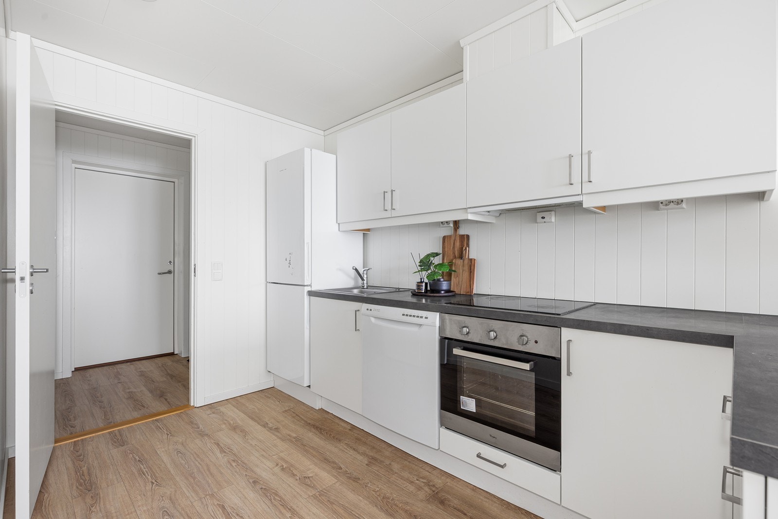 Lyst kjøkken med god benkplass. Hvitevarene følger leiligheten ved salg Galleribilde