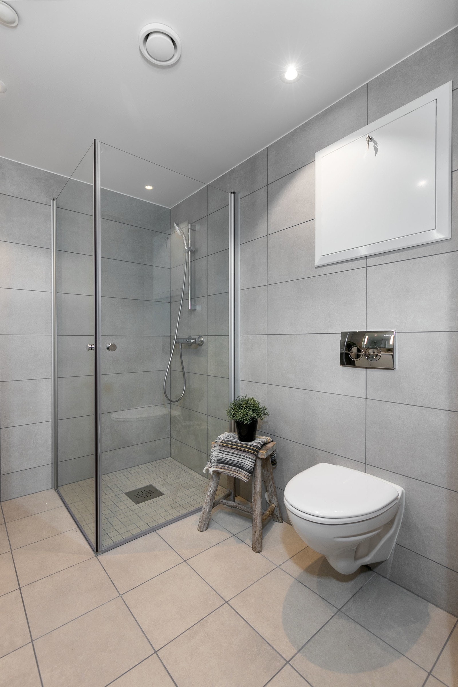 Badet har vegghengt toalett med innbygget sisterne, servant med skapinnredning samt speil med belysning. Galleribilde