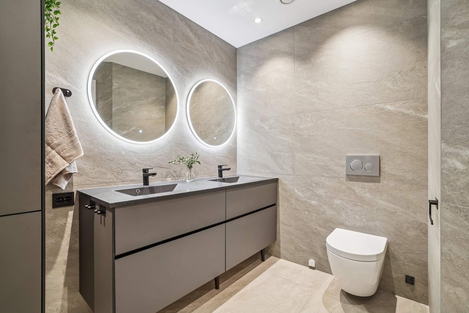 Badet er innredet med servantinnredning og høyskap fra Kvik med mørke fronter og helstøpt kompositt servantplate. To speil med integrert belysning. Galleribilde