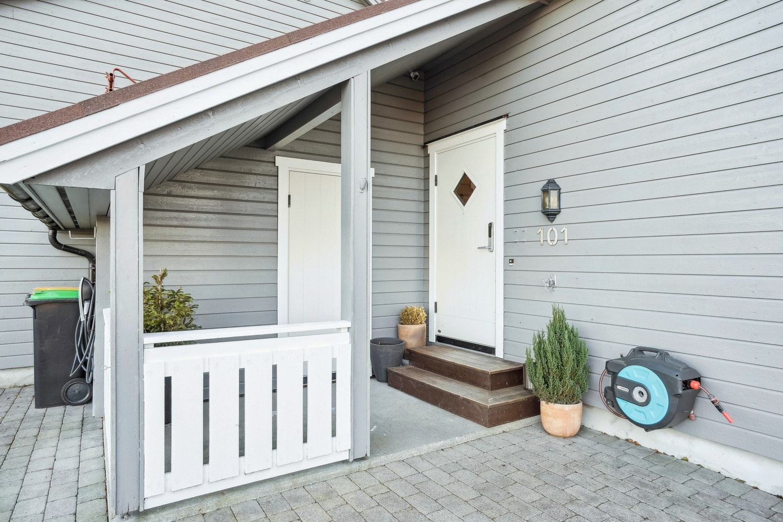 Pent overbygd inngangsparti med tilkomst til bod. Parkeringsplass med elbillader. Galleribilde