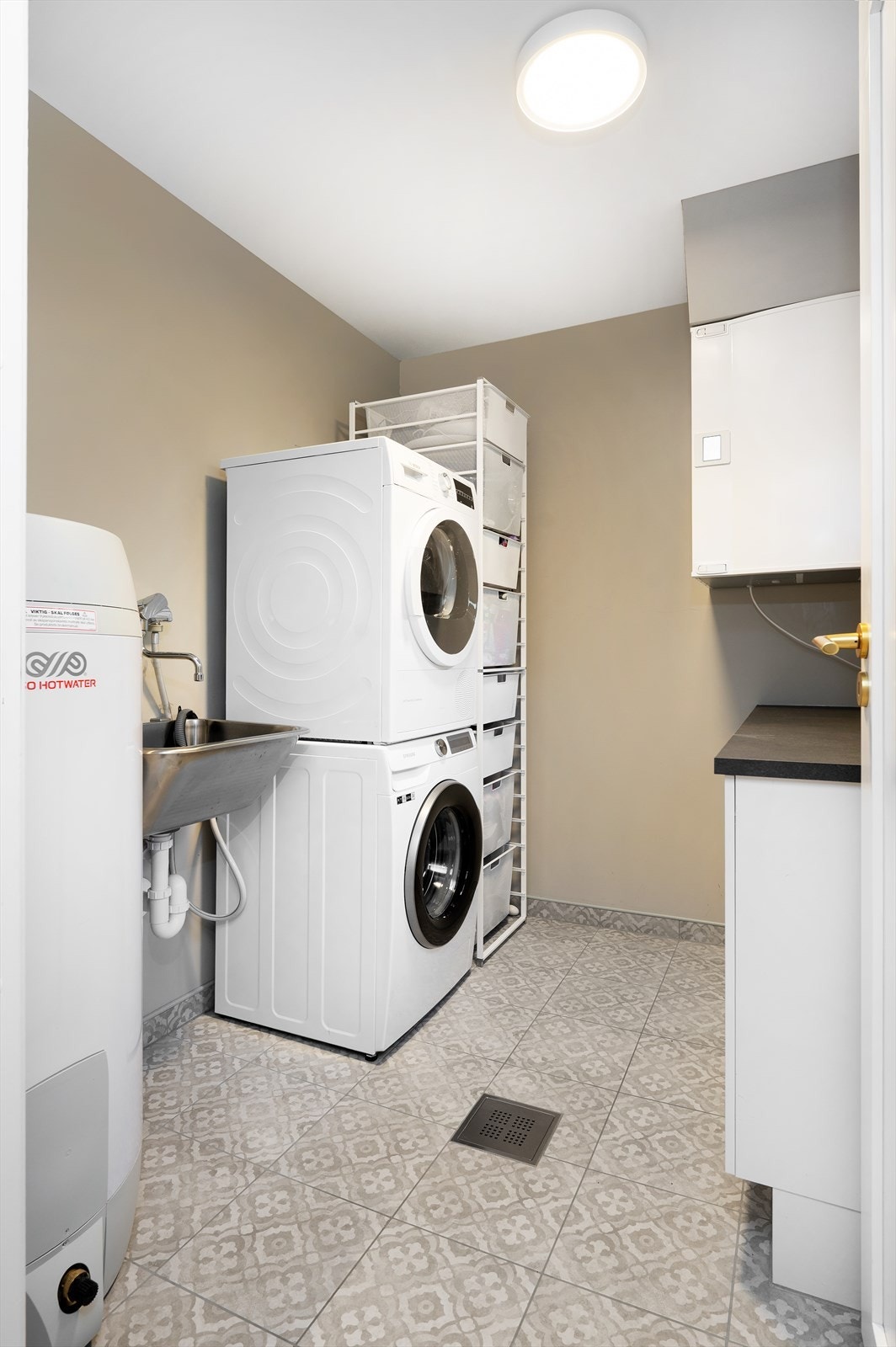 Flislagt vaskerom med varmekabler, god plass til vaskemaskin og tørketrommel og varmtvannstank på ca. 200 liter Galleribilde