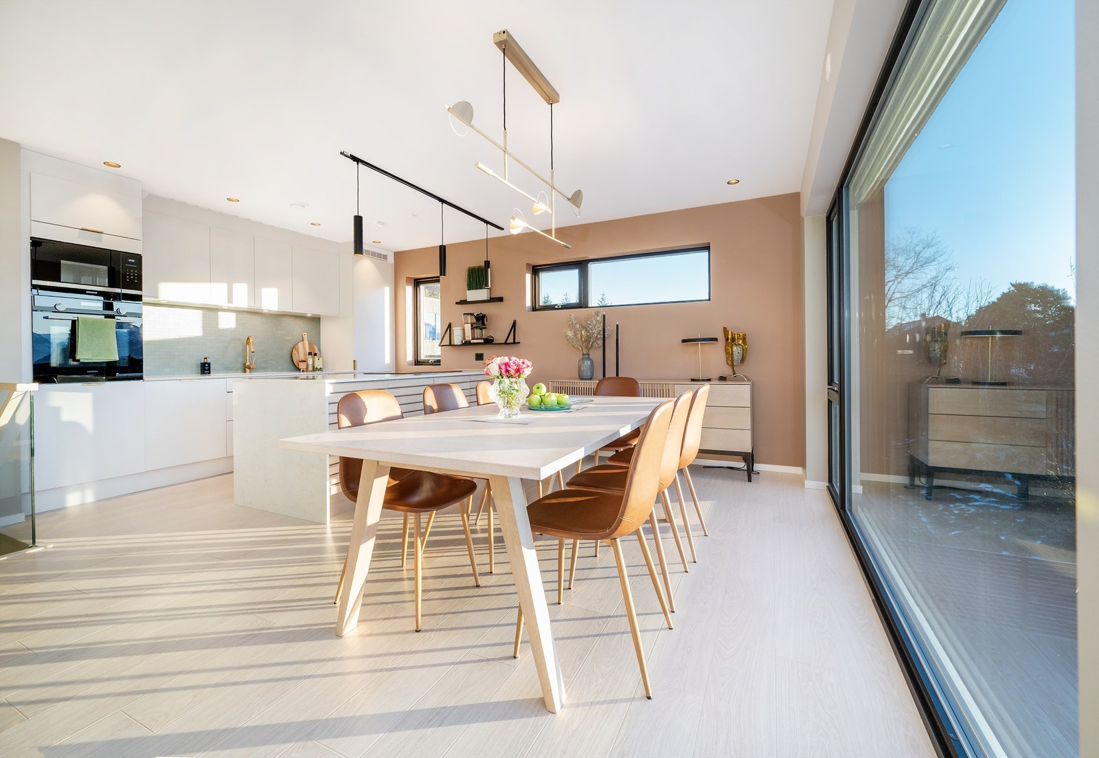 Kjøkkenet har innredning fra HTH med glatte hvite fronter og benkeplate av stein. Flott kjøkkenøy med skap på begge sider Galleribilde