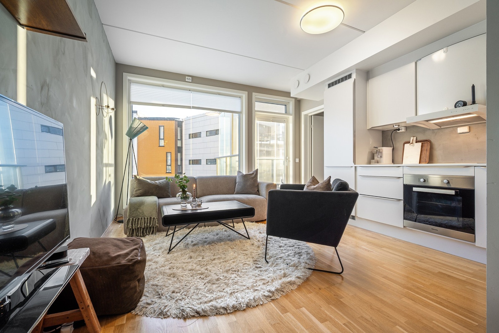 Den åpne stue- og kjøkkenløsningen skaper en lys og sosial sone Galleribilde