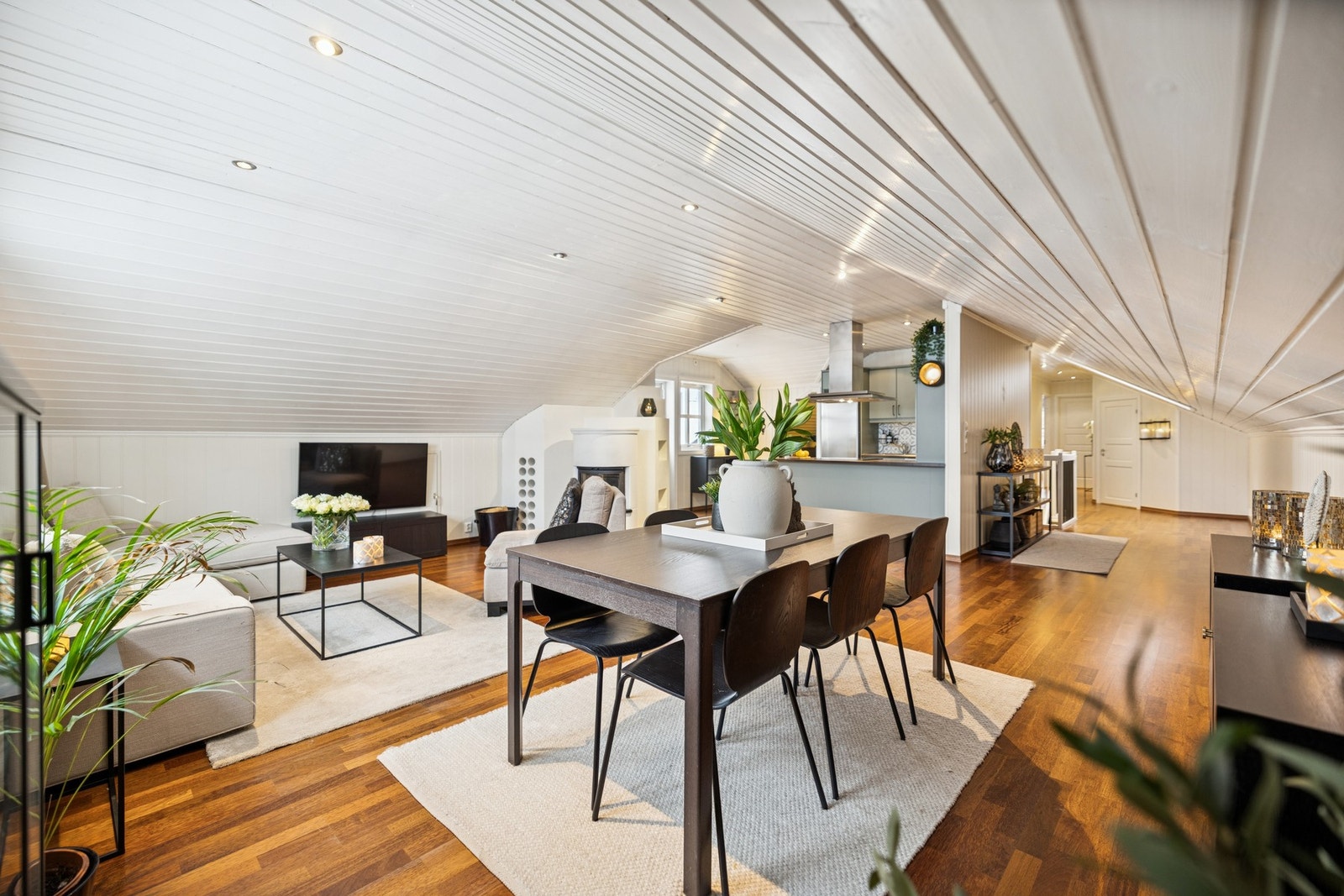 Stuen fremstår som lys og koselig med skråhimling og lyse overflater, og har god plass til både spisestue og sofagruppe. Peisinnsatsen gir lun varme og bidrar til en hyggelig atmosfære på kjølige dager. Galleribilde