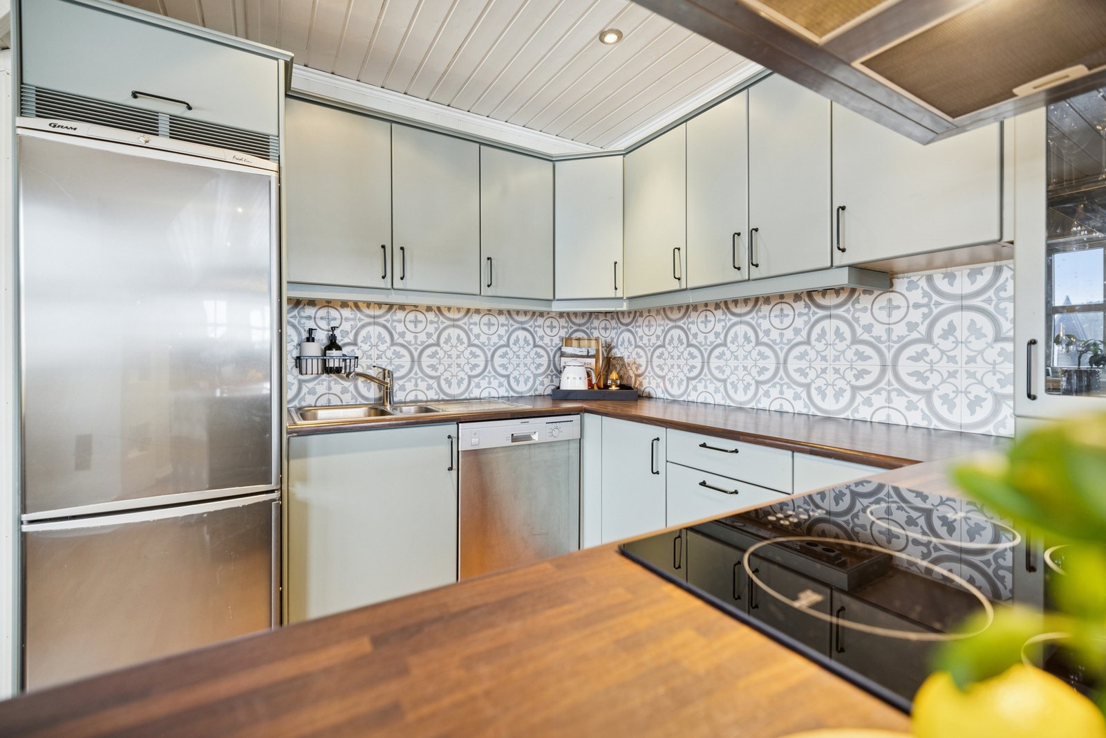 Lekre fliser i benkeryggen gir et tiltalende uttrykk, og et skap med vitrinefront fungerer som en fin og dekorativ detalj. Galleribilde