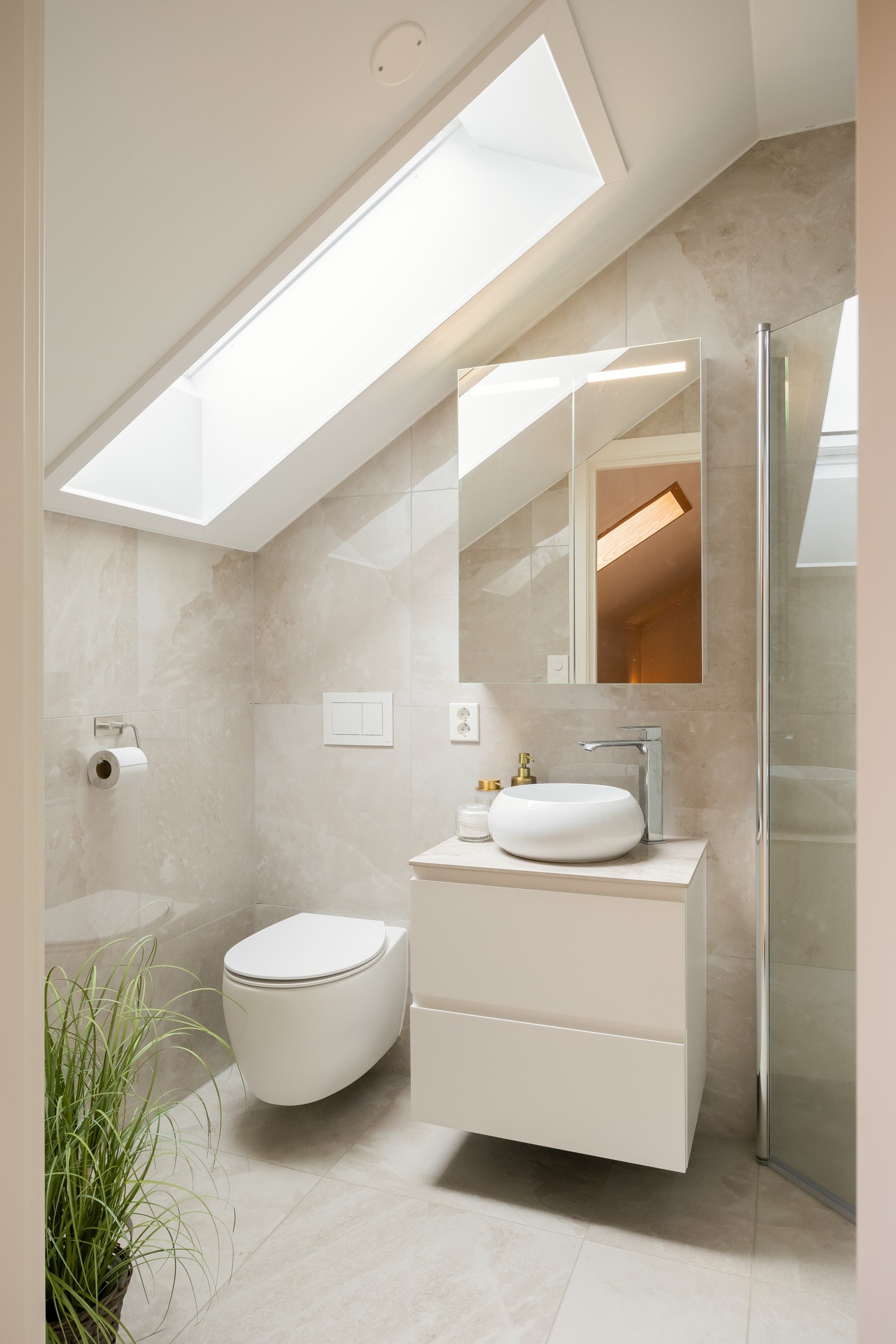 Badet er utstyrt med varme i gulvet, dusj, innredning med lekker servant og vegghengt toalett. Galleribilde