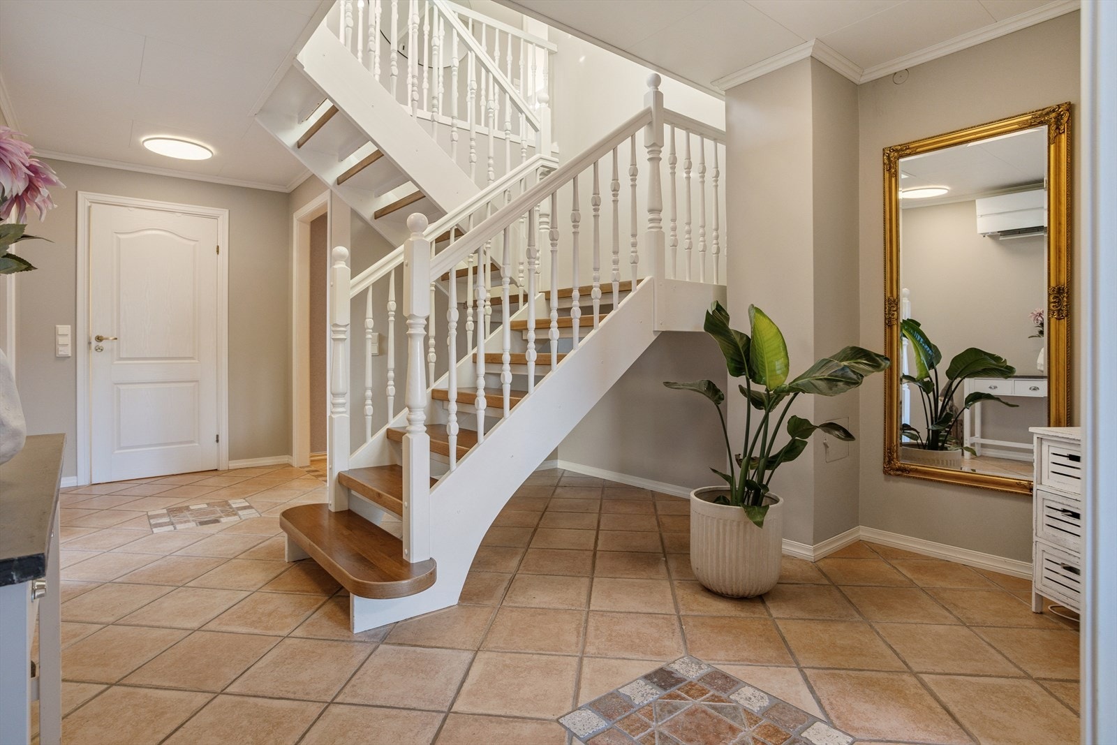 Fra hallen leder en hvitmalt tretrapp med valnøtt parkett i trinnene deg opp til første etasje. Galleribilde