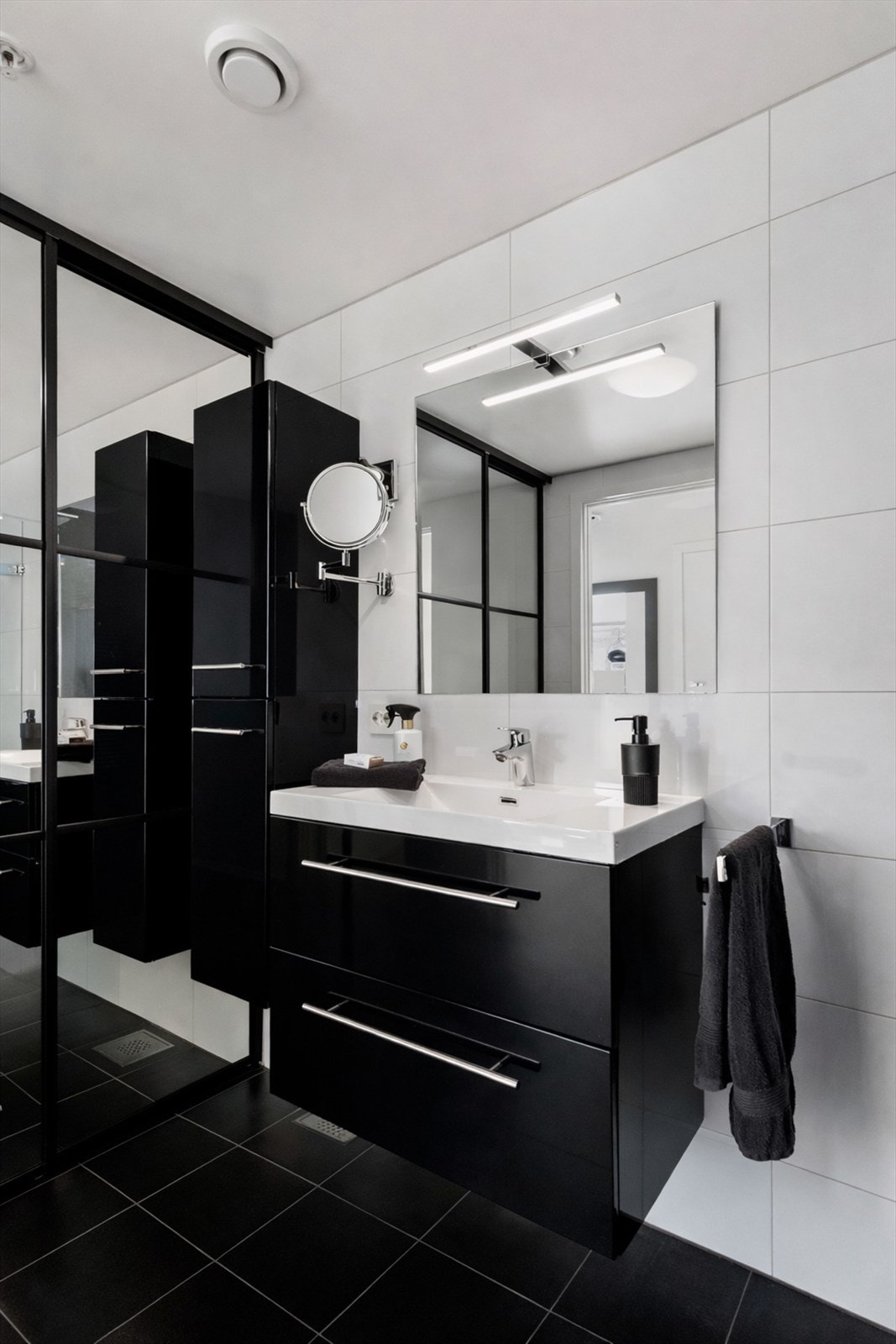 Baderomsinnredning i sort høyglans med doble skuffer og heldekkende servant. Galleribilde