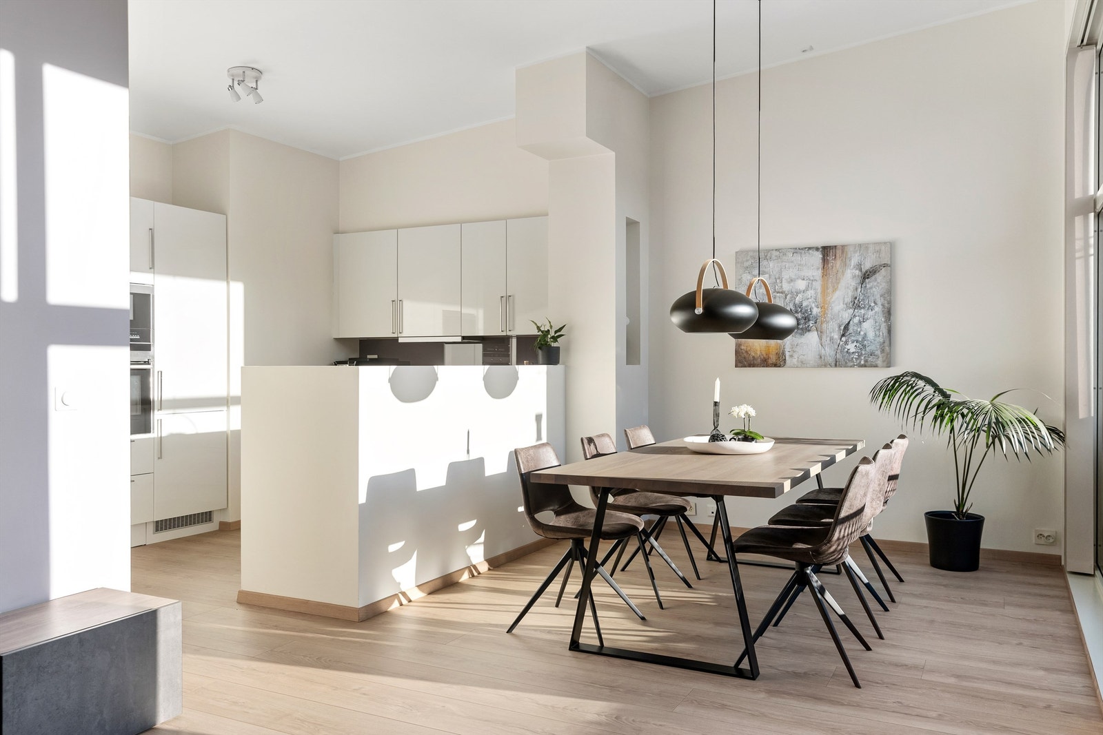 Halvveggen mot kjøkkenet definerer sonene, men beholder åpenheten. Galleribilde