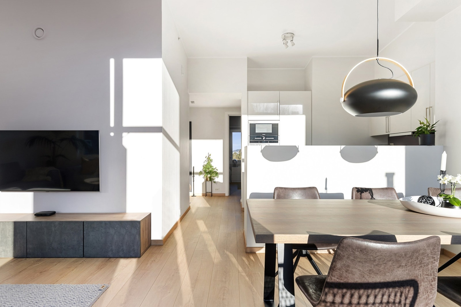 Gjennomlys og åpne flater preger leilighetens sosiale sone. Galleribilde