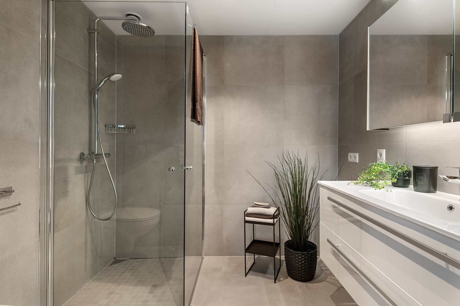 Badet er innredet med dushjørne, vegghengt toalett, servant og skapspeilt. Opplegg for vaskemaskin. Galleribilde