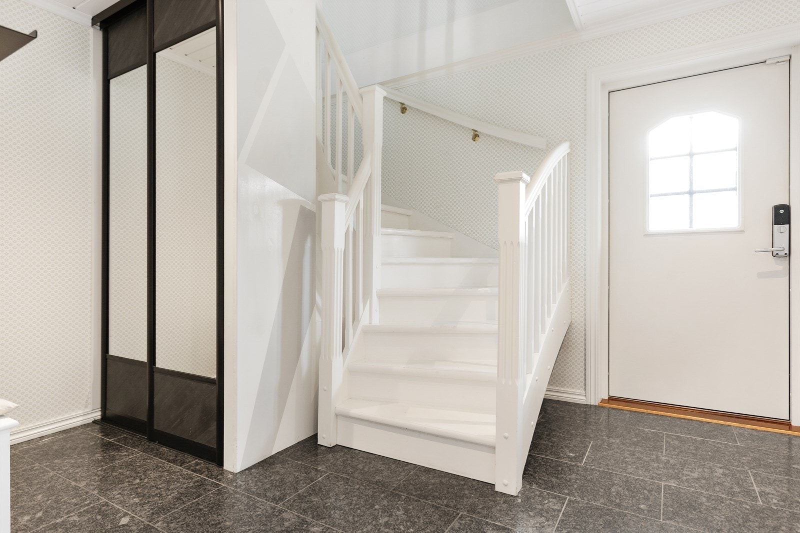 Entréen er praktisk, med god plass til oppbevaring av yttertøy og sko. Den fungerer som et naturlig knutepunkt med tilgang til boligens øvrige rom. Galleribilde