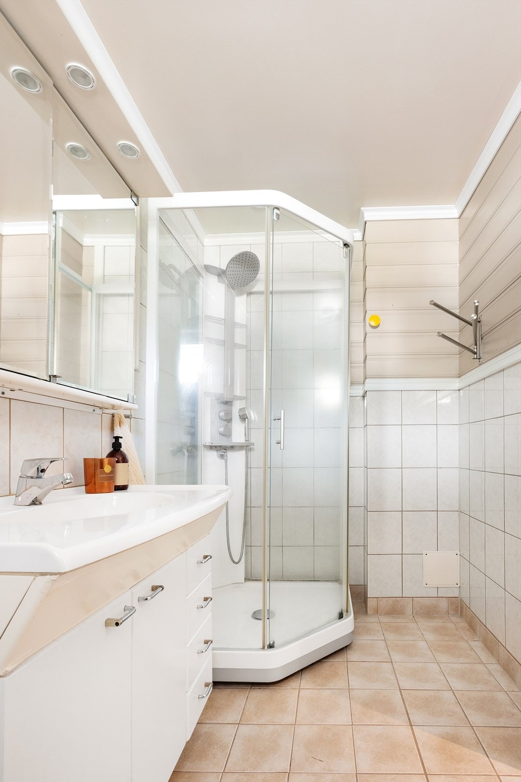 Badet stammer fra byggeåret og har fliser og malt panel på veggene, samt malt tak med innfelt belysning. Gulvet er flislagt og utstyrt med elektriske varmekabler for god komfort. Galleribilde