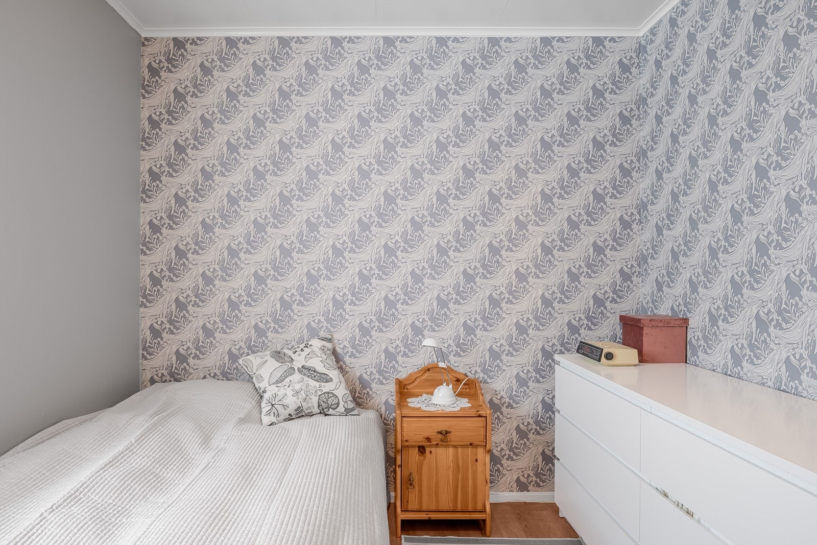 Soverommet har pent laminatgulv og glatte malte overflater kombinert med to tapetserte vegger. Galleribilde