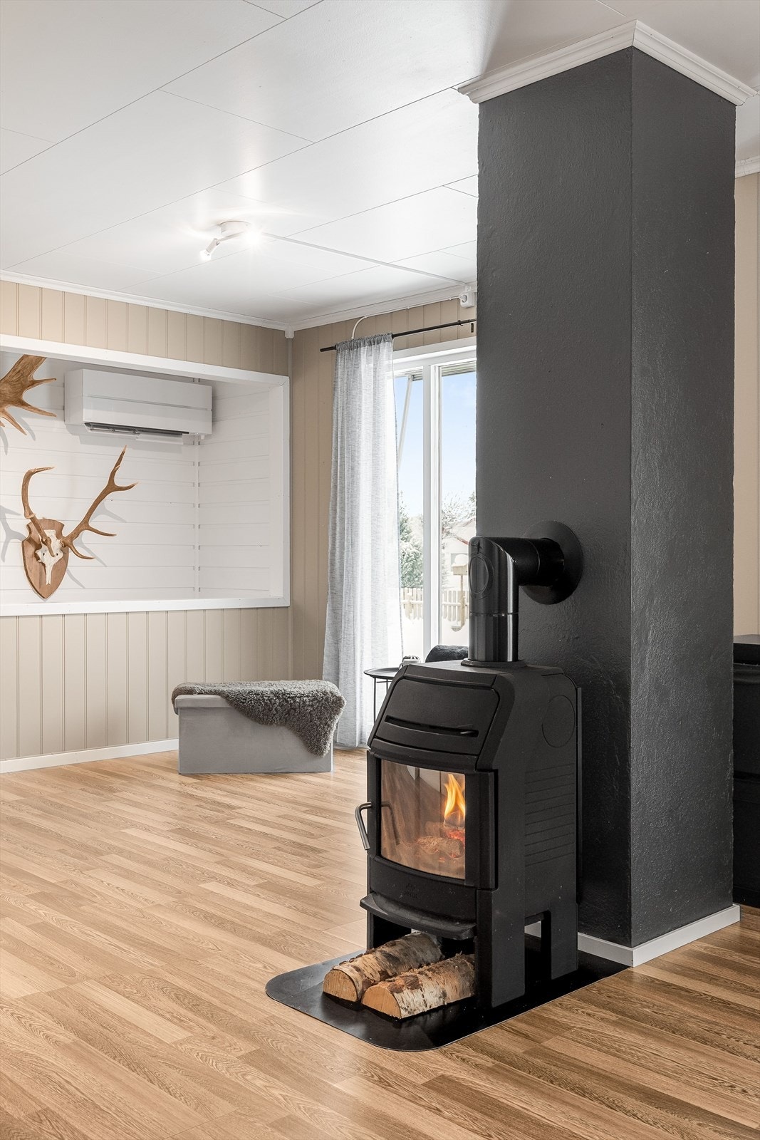 Som et naturlig midtpunkt i stuen er det en koselig peisovn som både gir god varme og bidrar til ekstra hygge. Galleribilde