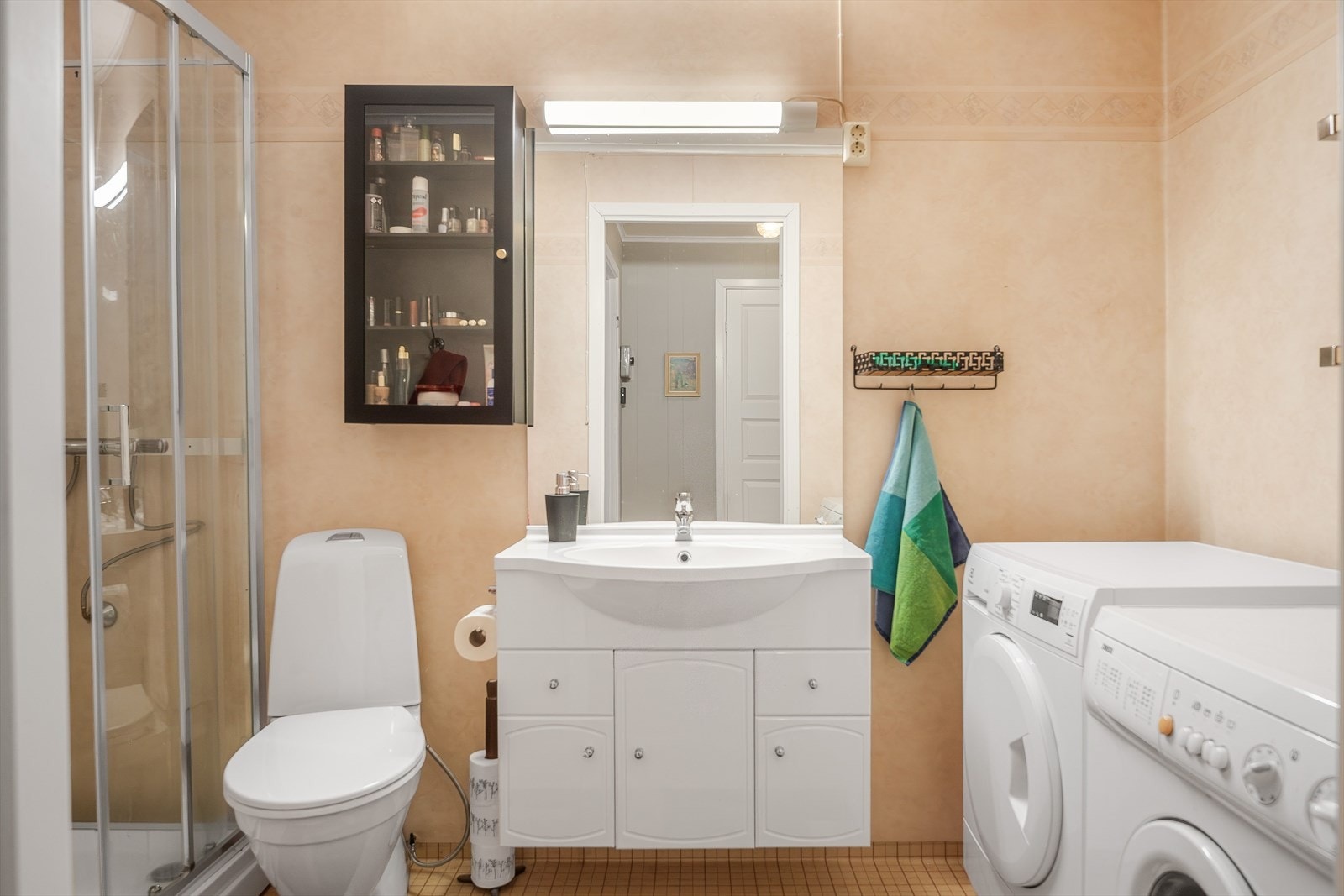 Baderommet i utleieleiligheten har våtromsbelegg på gulv, vinylbelegg fra ca. 2007 på veggene, stråleovn og mekanisk avtrekk. Galleribilde