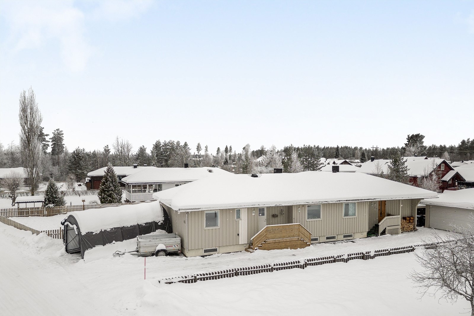 En solrik eiendom som er bebygd med en enebolig med tilbygget utleieleilighet og en frittstående garasje. Galleribilde