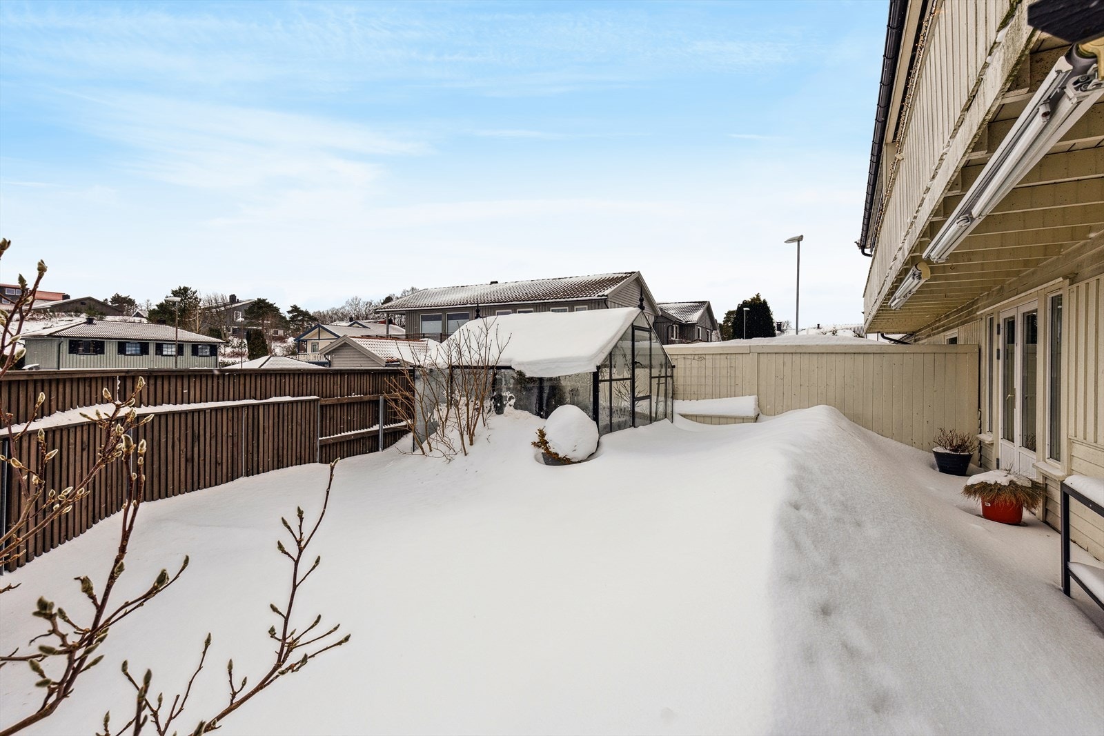 Eiendommen er opparbeidet med asfaltert gårdsrom, hage, variert beplantning og terrasseplatting. Galleribilde