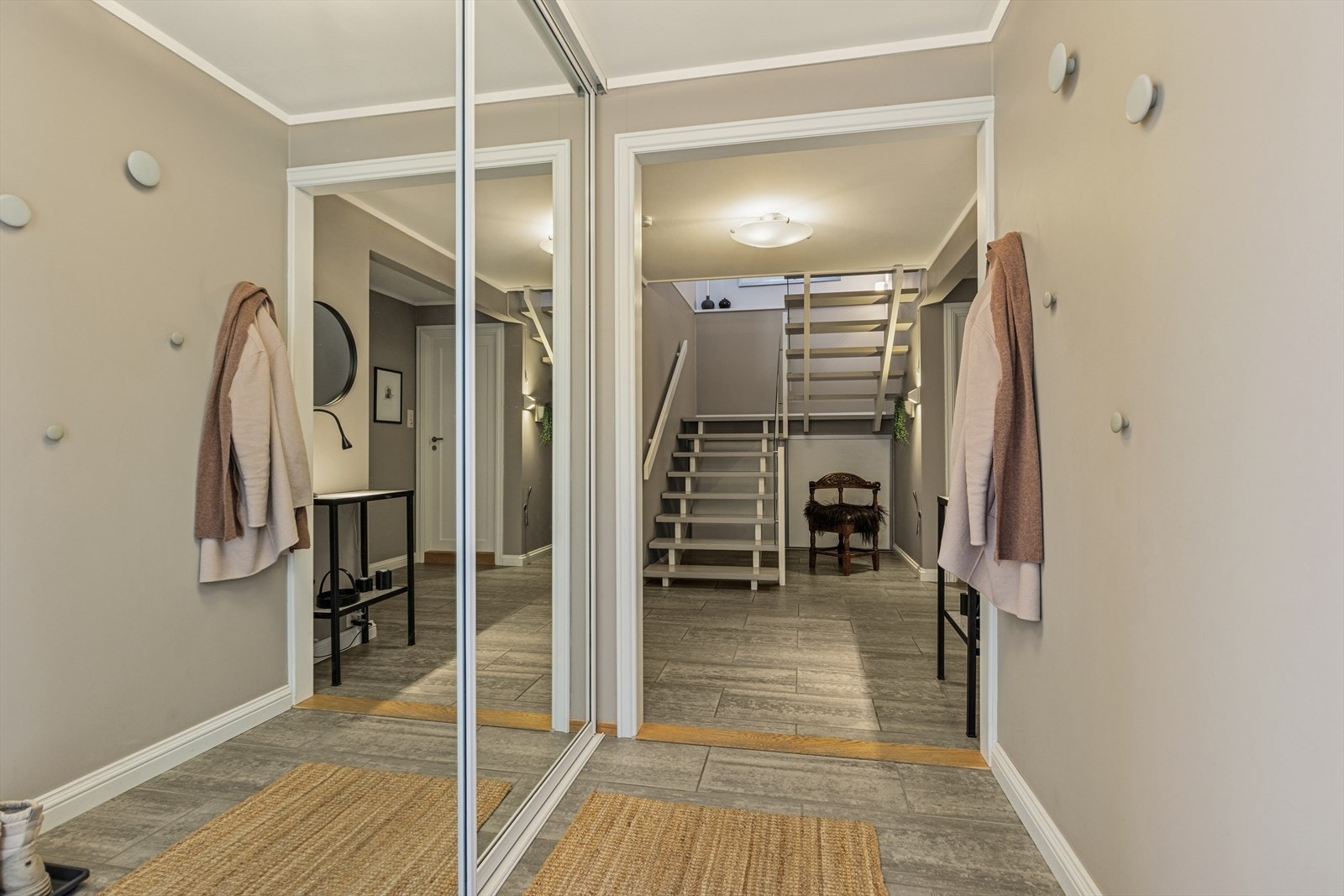 Hjemmet har en innbydende entré med flislagt gulv og en praktisk skyvedørsgarderobe med speilfronter. Galleribilde