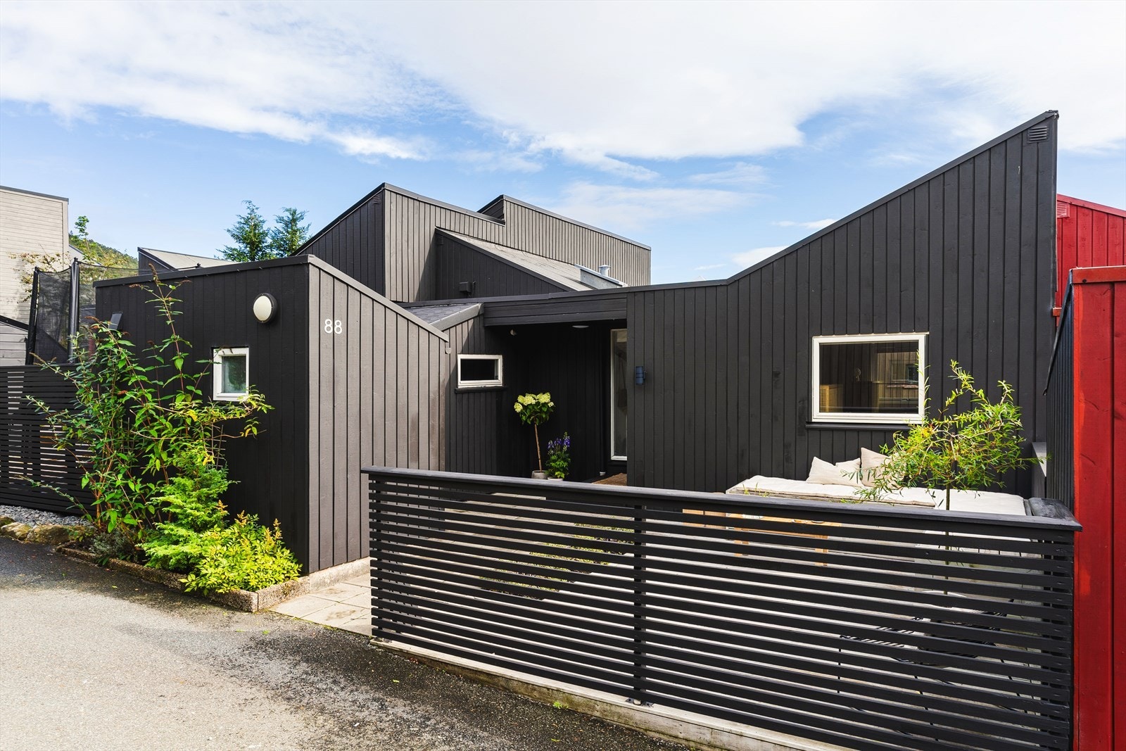 Boligen har en stilren fasade med stående og liggende trekledning, som ble byttet i 2021. Galleribilde