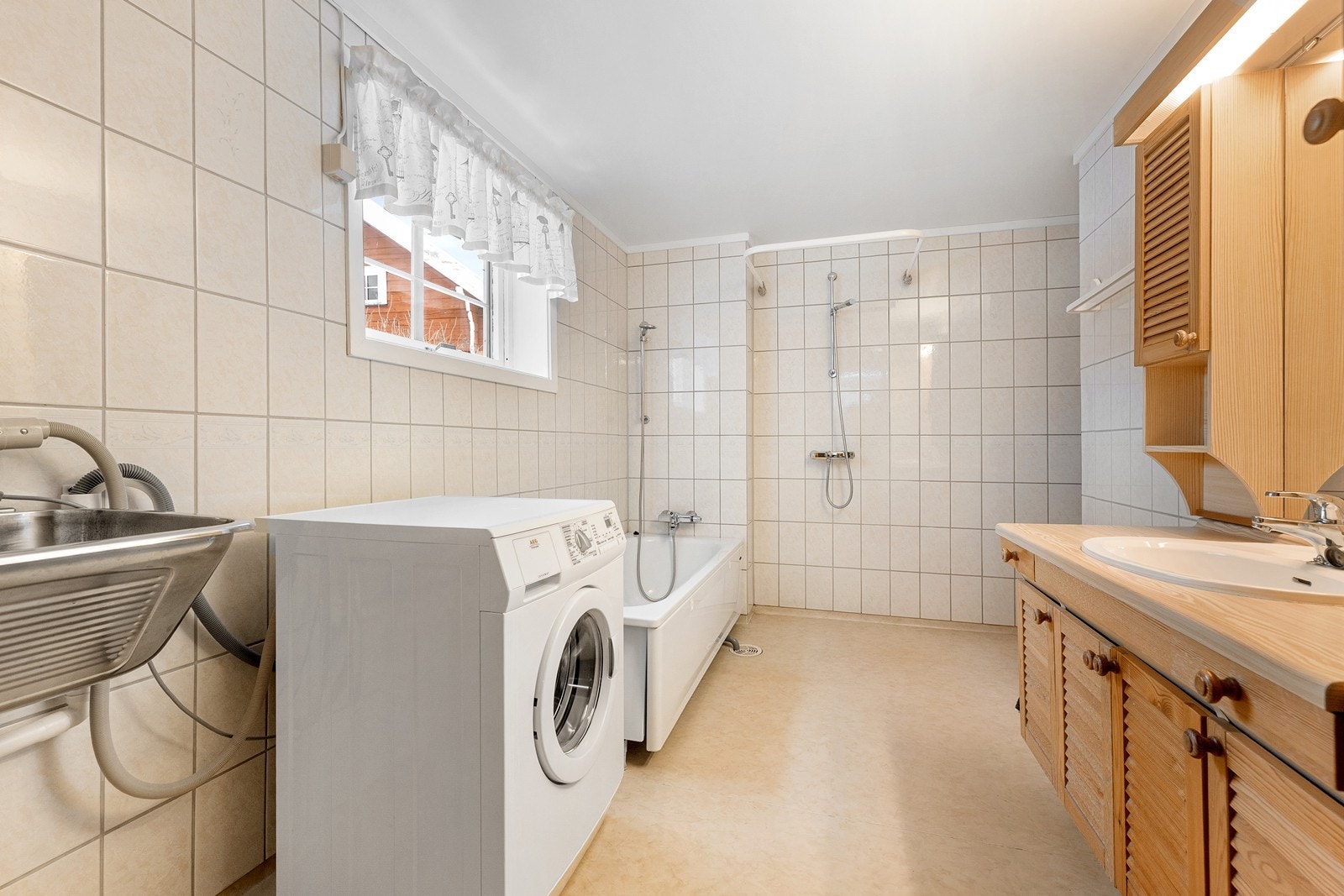 Baderom av god størrelse med flislagte vegger og baderomsbelegg på gulv. Galleribilde