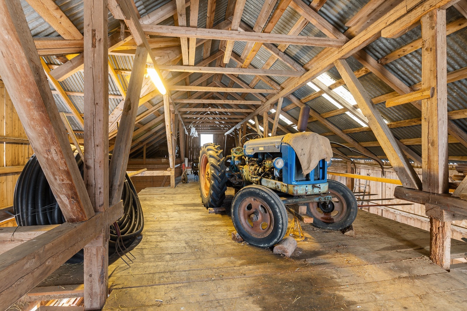 I låven står det en traktor av typen Fordson Major 1958 modell, som medfølger i handelen. Galleribilde