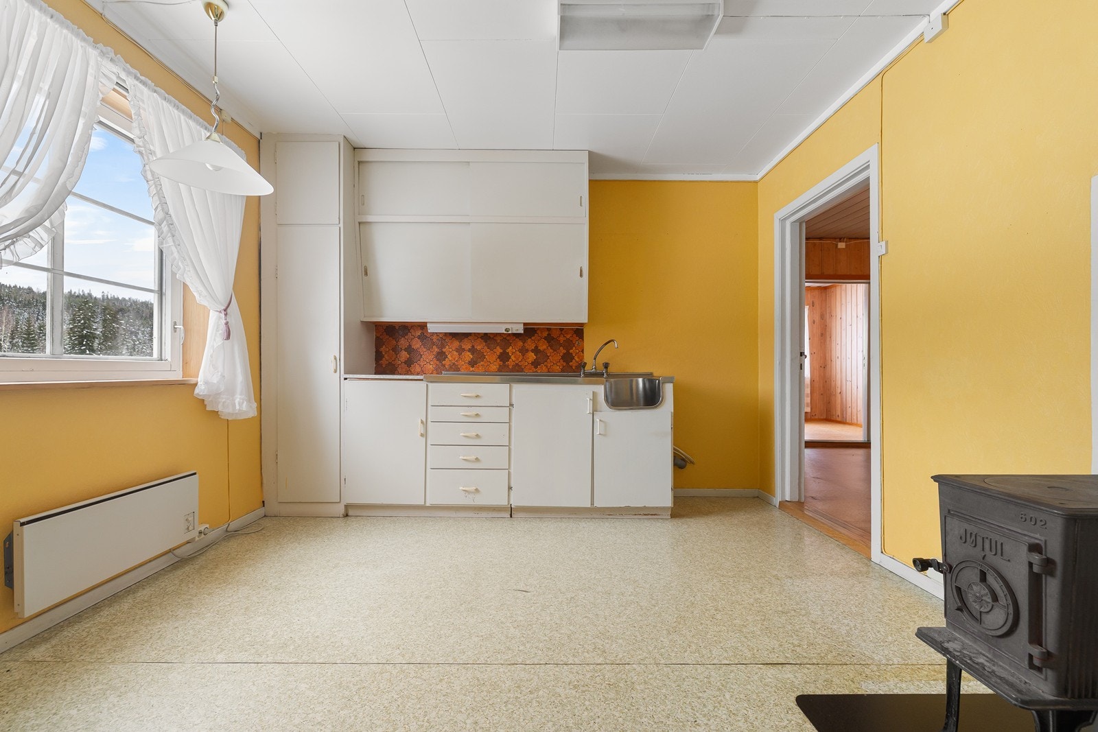 Kjøkken i 2. etasje med eldre kjøkkeninnredning langs en vegg. Galleribilde