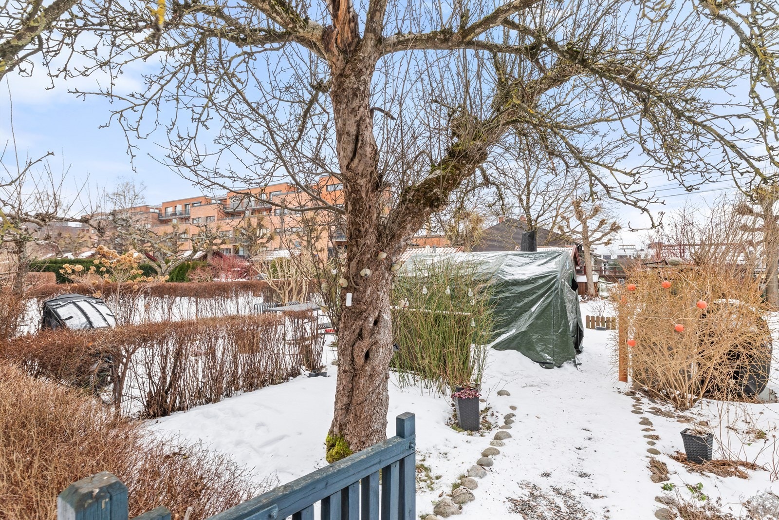 Utområde består av brosteinsbelagte gangstier, grønne flater og beplantning som skaper et innbydende hagemiljø. Galleribilde