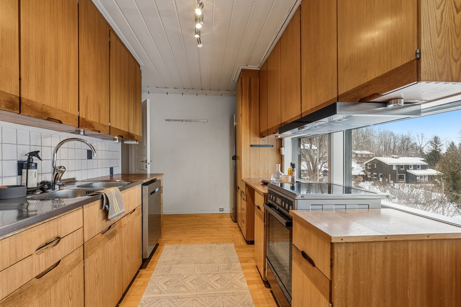 Eldre kjøkken med glatte fronter og benkplate i heltre. Galleribilde