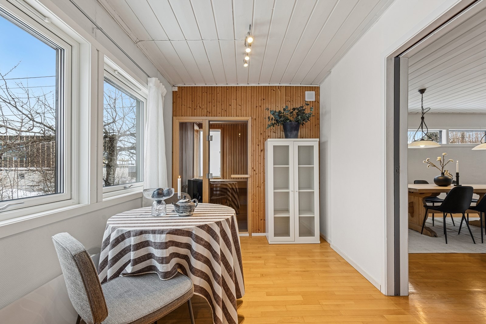 Liten sittegruppe rundt forkostbordet og inngang til badstuen. Galleribilde