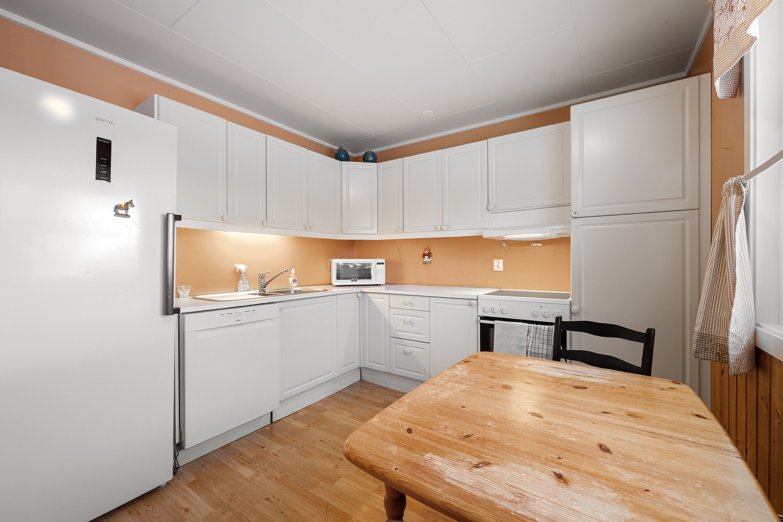 Lys seksjonsinnredning med profilerte fronter og god skapplass Galleribilde