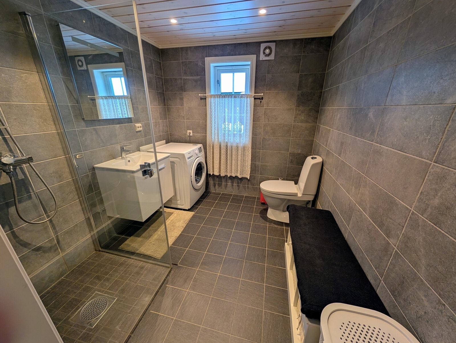 Romslig, flislagt bad med god plass til vaskemaskin. Galleribilde