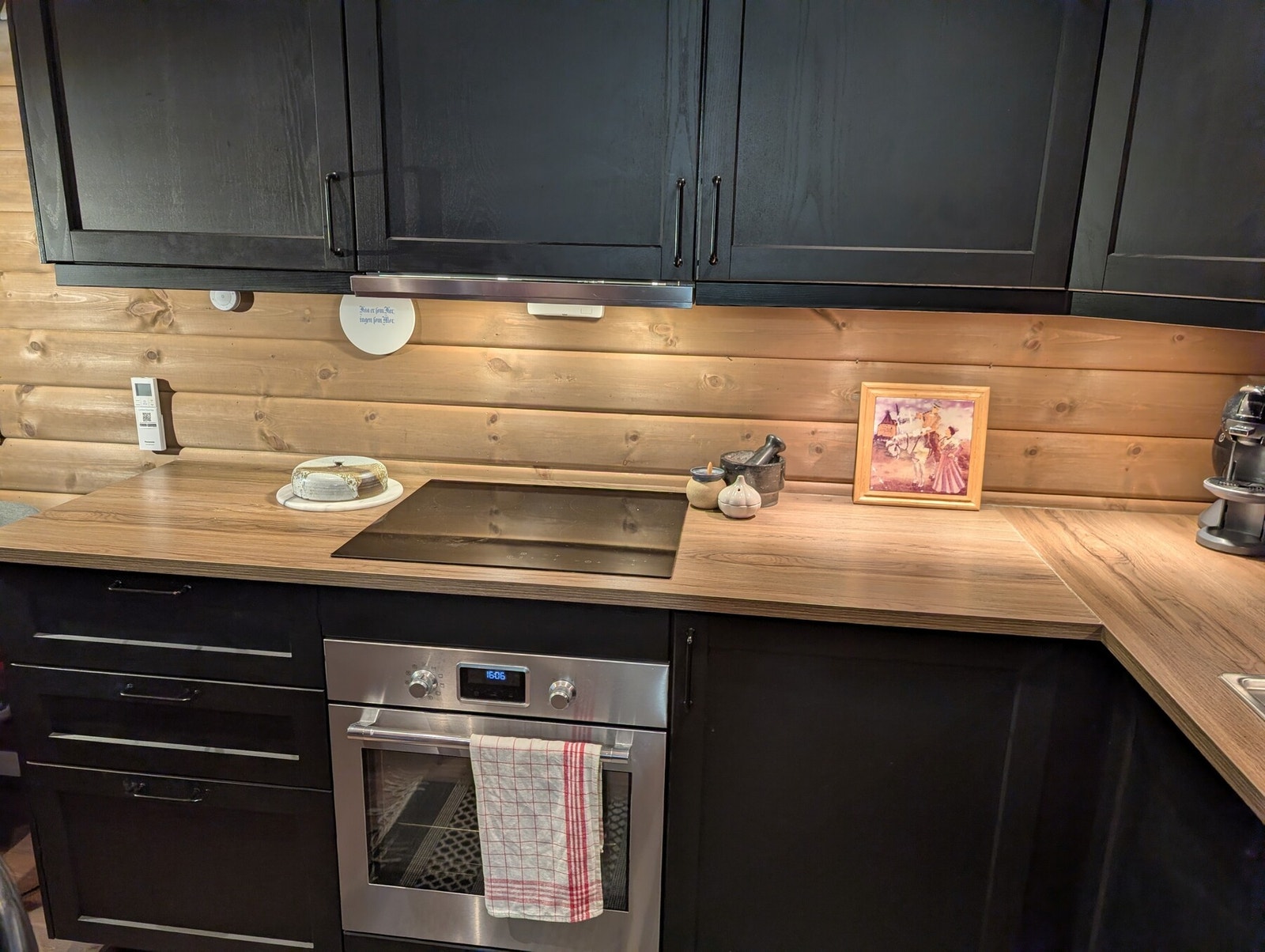 Integrert stekeovn og helhetlig uttrykk med mørk innredning. Galleribilde