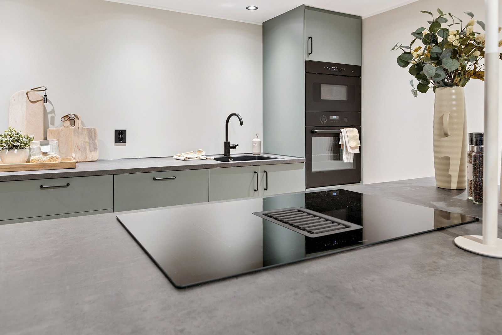 Moderne induksjonstopp med integrert ventilator - en praktisk og plassbesparende løsning som gir et ryddig kjøkkenuttrykk. Galleribilde