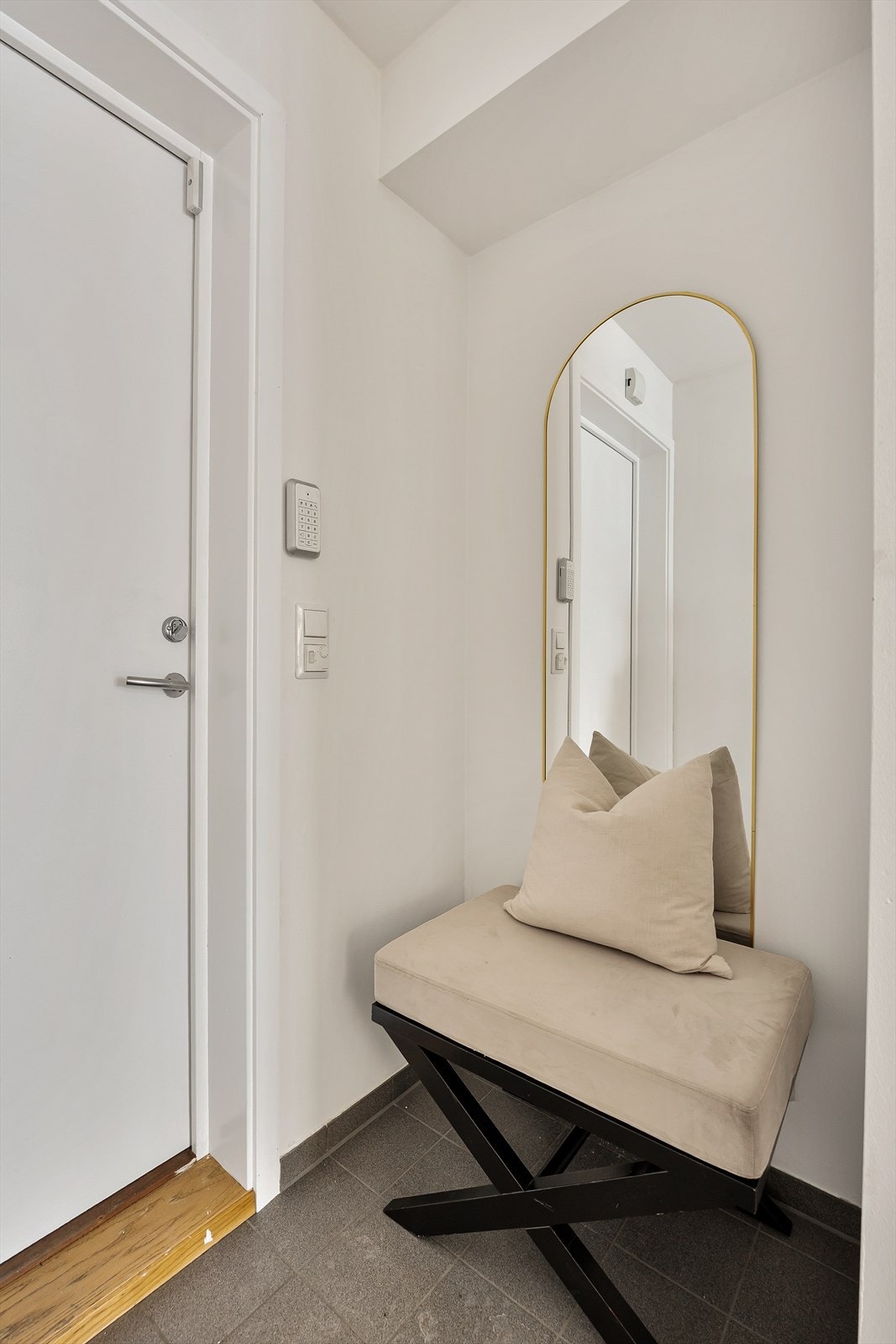 Velkommen inn i en lys entré med slitesterke fliser på gulvet. Galleribilde