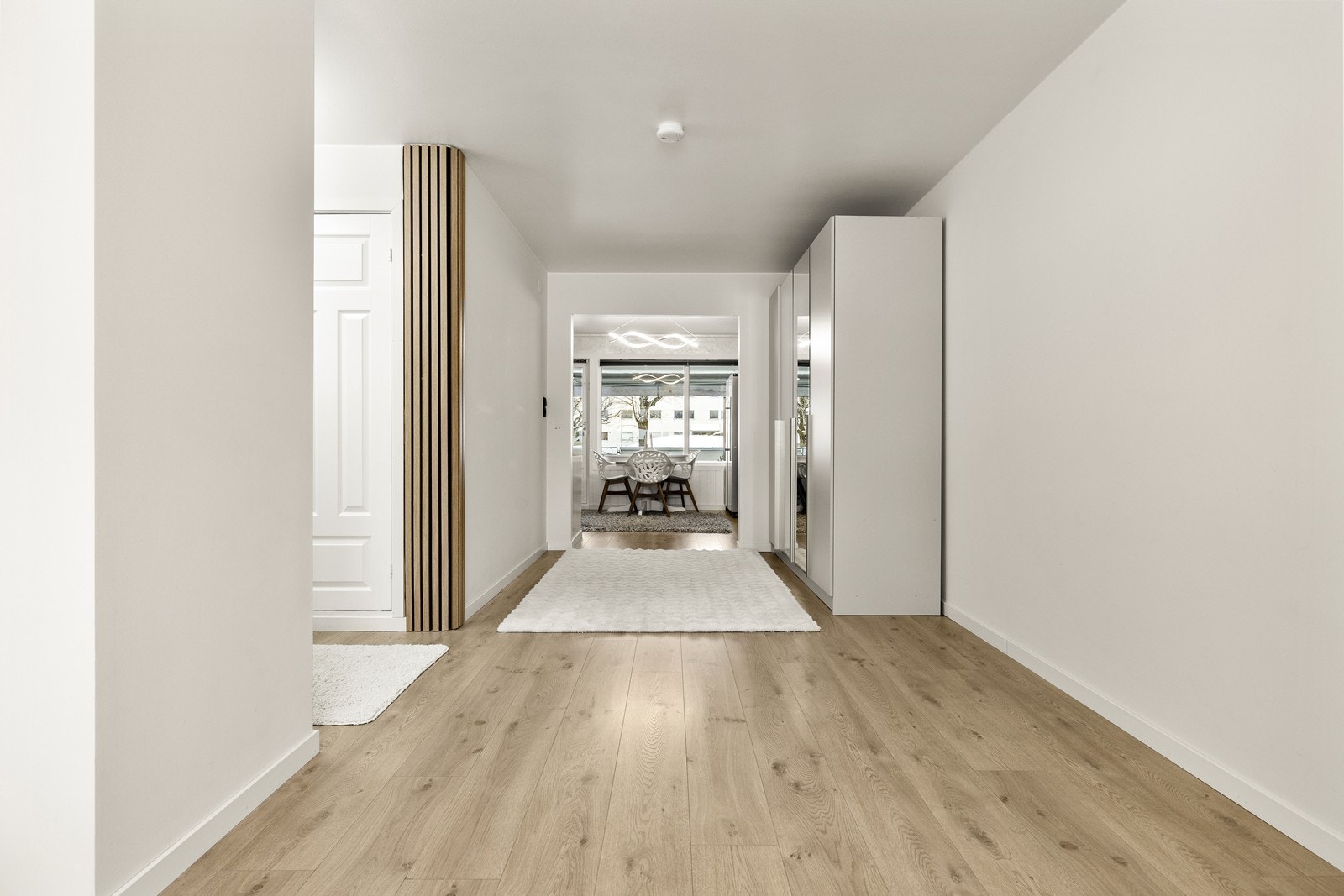 Gjennomgående laminatgulv og lyse overflater skaper en helhetlig stil. Galleribilde