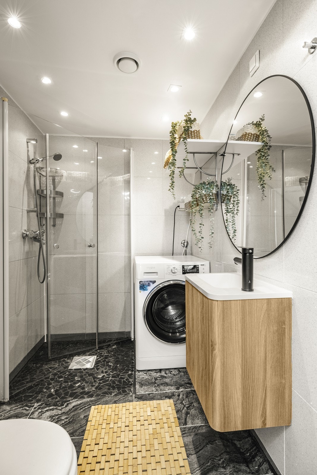 Delikat bad med flislagte overflater, gulvvarme og dusjhjørne med svingbare glassdører. Galleribilde