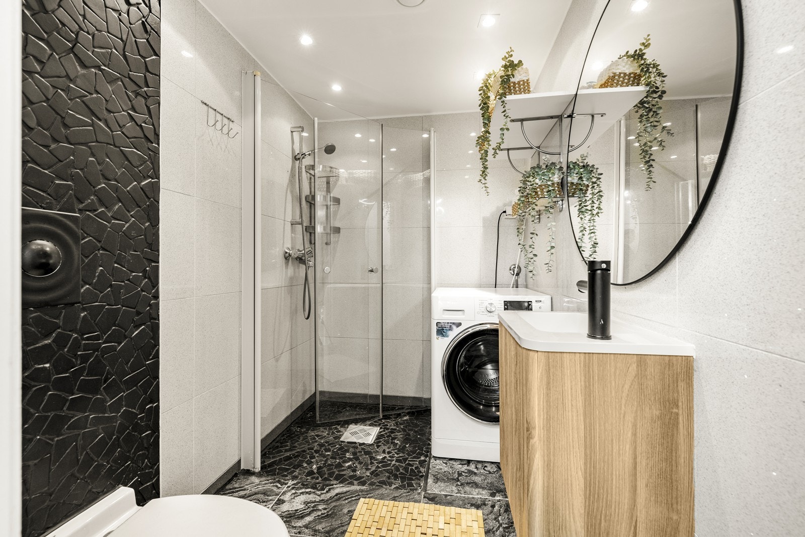 Badet er utstyrt med vegghengt klosett, servantinnredning og opplegg for vaskemaskin. Galleribilde