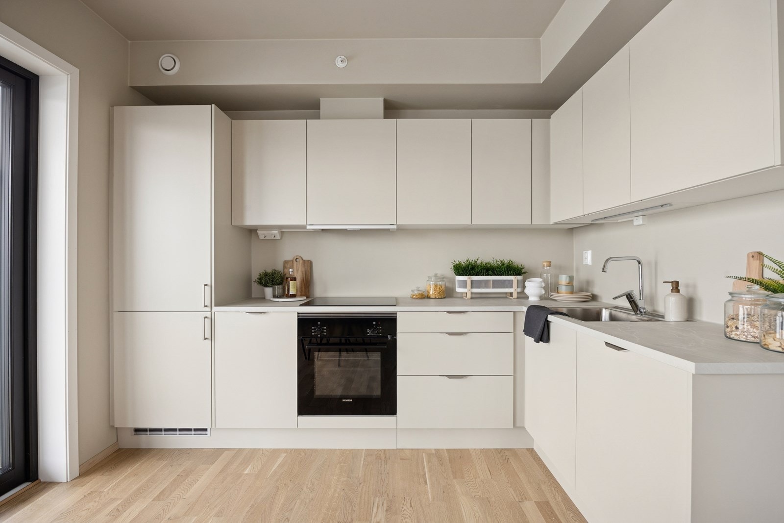 Kjøkken med lyse fronter og laminat benkeplate. Galleribilde