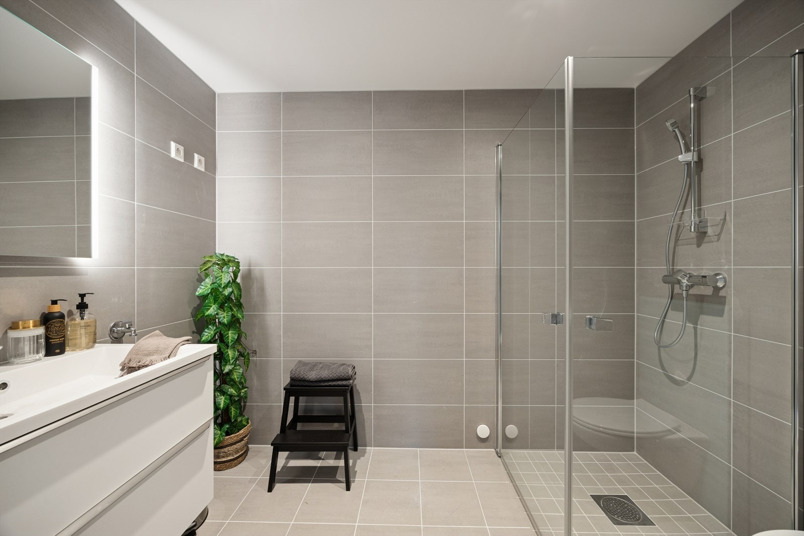 Pent flislagt bad med dusjhjørne og innfellbare dusjvegger. Galleribilde