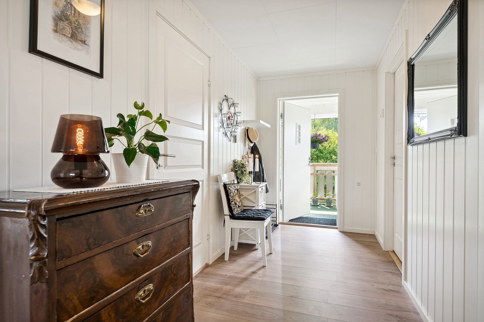 Romslig entré i tidløs utførelse med plass til kommoder og skohylle. Galleribilde