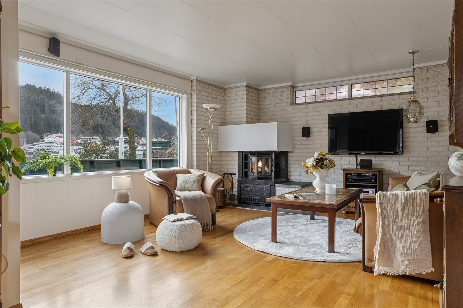 De store vinduene slipper inn rikelig med dagslys og gir en rolig atmosfære, mens vedovnen gjør rommet varmt og innbydende gjennom hele året. Galleribilde