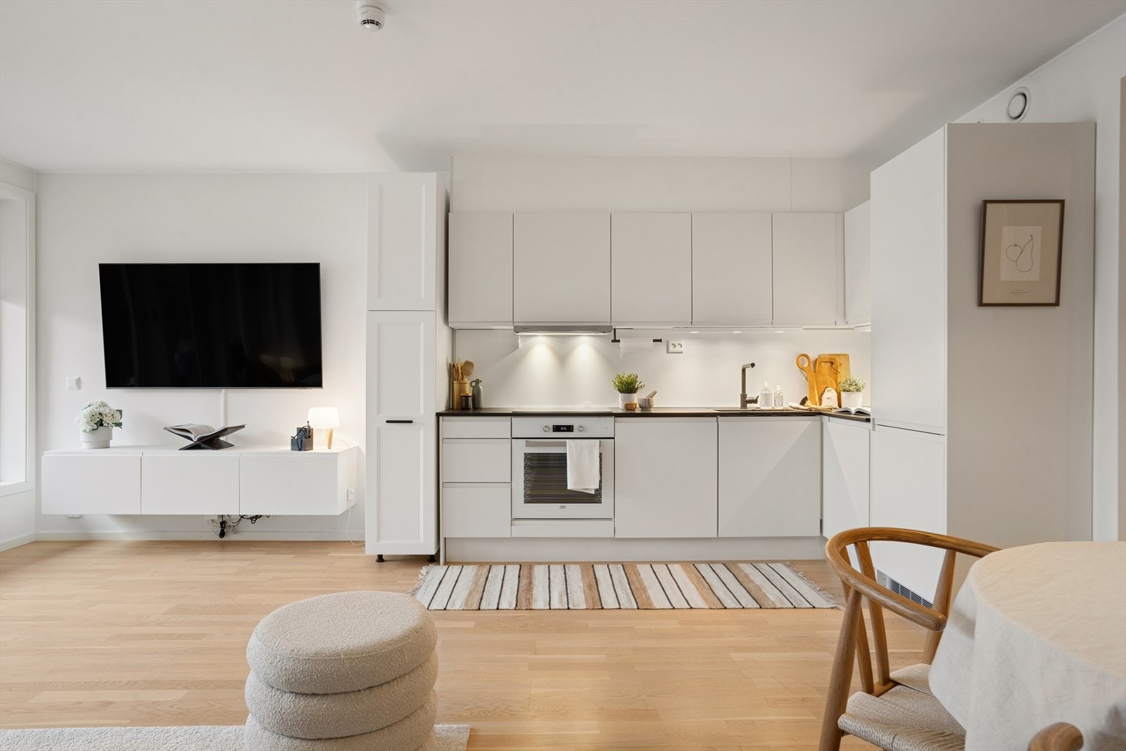 God arbeidsflate, integrerte løsninger og rene linjer gjør dette til et svært praktisk kjøkken som både er lett å bruke og enkelt å holde ryddig. Et elegant samlingspunkt som glir sømløst inn i den åpne stue-/kjøkkenløsningen. Galleribilde