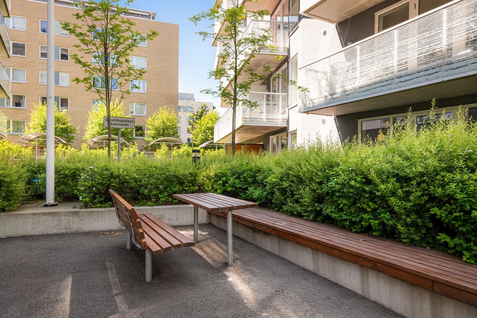 Pent og opparbeidet uteareal med beplantning, sittegrupper og lekeapparater. Galleribilde