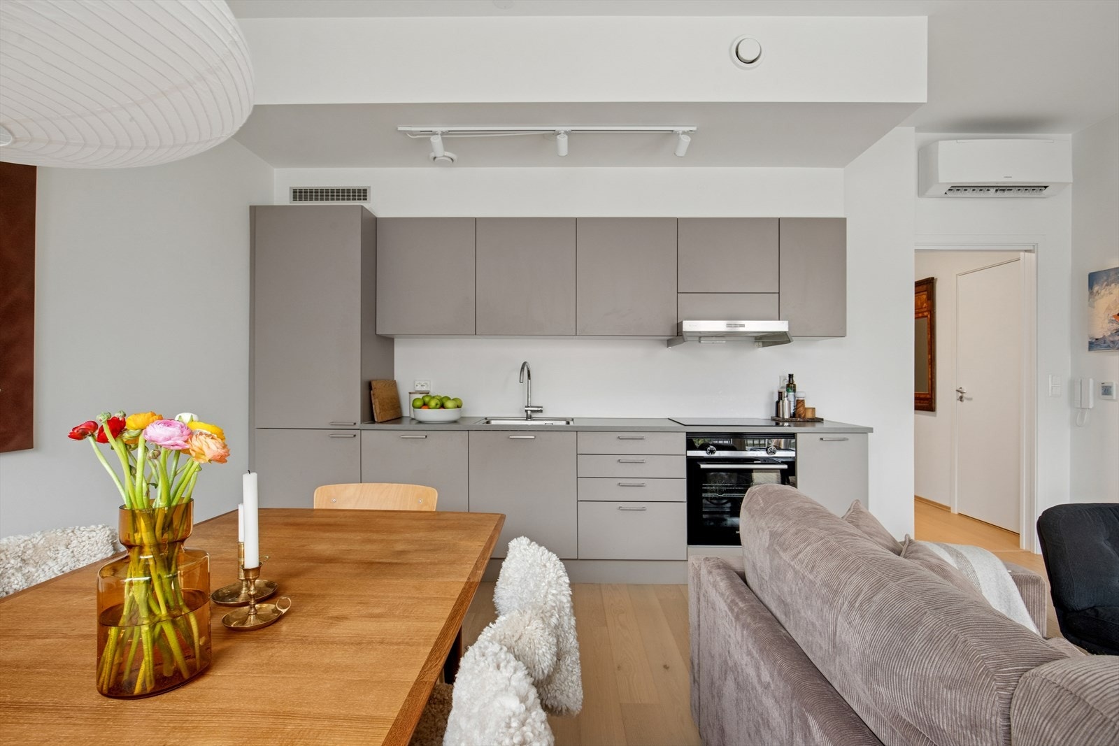 Kjøkkenet er innredet med beige, slette fronter og grå benkeplate i laminat. Et praktisk og stilrent kjøkken som er utstyrt med kjøleskap, oppvaskmaskin, stekeovn, platetopp og kjøkkenventilator med mekanisk avtrekk i boenheten. Galleribilde